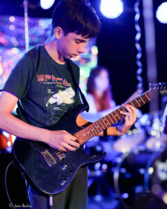 Zack playing guitar on stage at The Brass Monkey